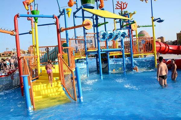 Wasserspielplatz im Malikia Resort Abu Dabbab mit bunten Strukturen und Kindern, die spielen.