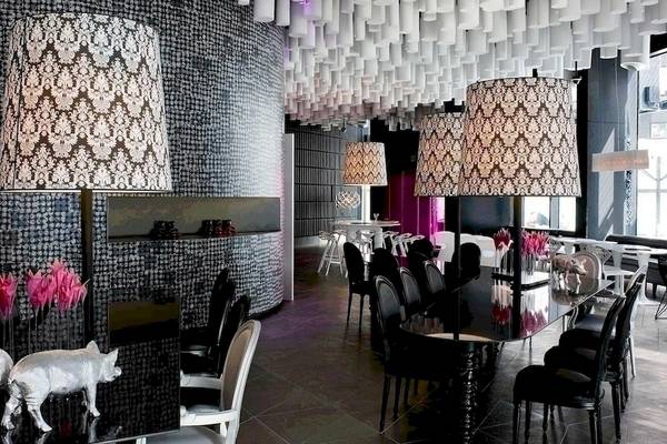 Inneneinrichtung des Barcelo Raval Hotels mit schwarz-weißem Muster, großen Lampen und rosa Akzenten.