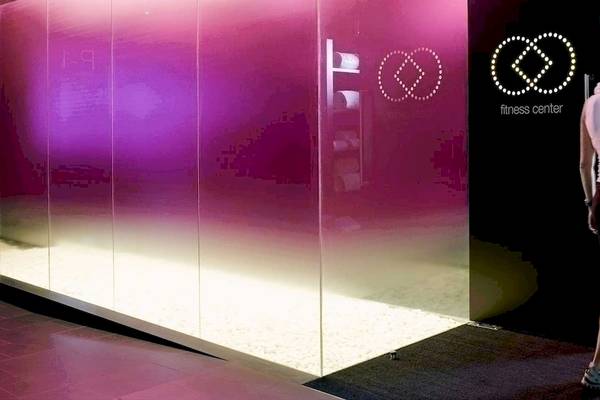 Eine Frau steht vor dem Eingang des Fitness Centers im Barcelo Raval Hotel.