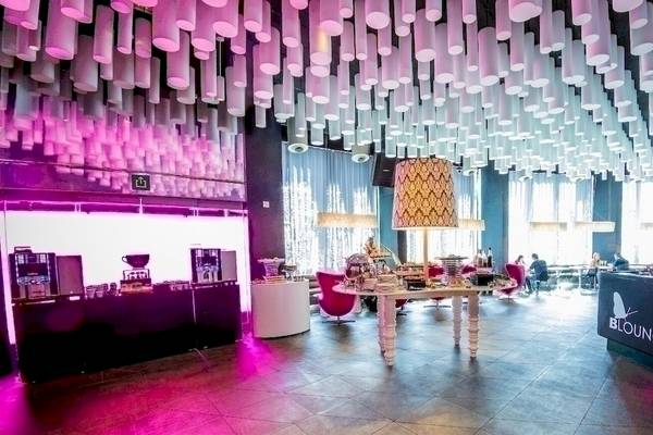 Lobby des Barcelo Raval Hotels mit lila Beleuchtung und modernen Möbeln.