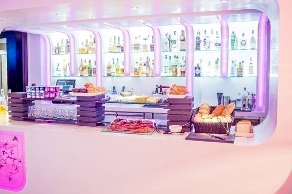 Rezeption mit Frühstücksbuffet im Barcelo Raval Hotel, serviert auf einer Theke mit einer Auswahl an Getränken und Gebäck.