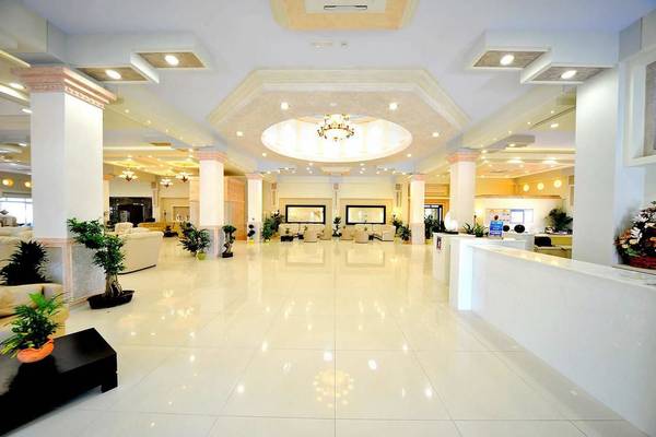 Foyer des Gaia Palace Hotels mit weißen Marmorboden und Pflanzendekoration.