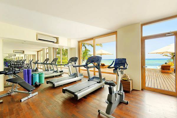 Fitnessraum im Melia Zanzibar mit Blick auf das Meer und eine Terrasse.