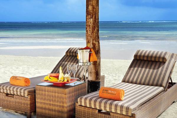 Zwei Strandliegen des Melia Zanzibar mit Früchten und Getränken auf einem Tisch.