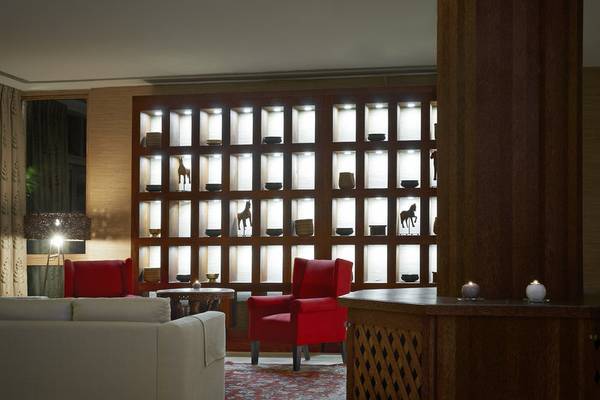 Loungebereich des Melia Zanzibar Hotels mit roten Sesseln und einer beleuchteten Wand.