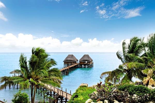 Zwei traditionelle afrikanische Hütten am Wasser des Melia Zanzibar Hotels