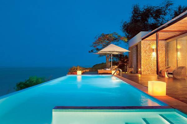 Ein Swimmingpool mit Blick auf das Meer im Melia Zanzibar Hotel am Abend.