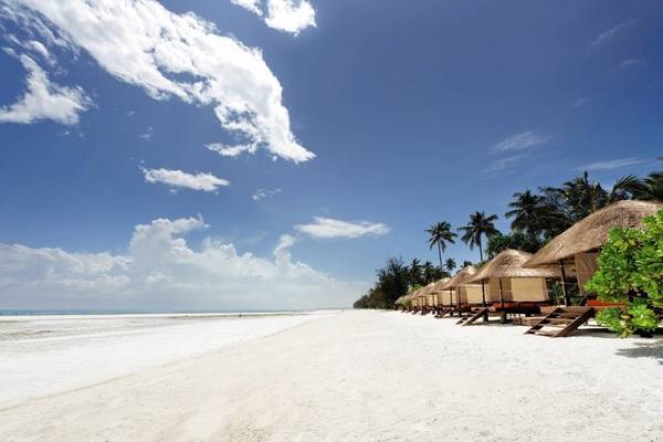 Strand des Melia Zanzibar Hotels mit Reihe von runden Strohhütten