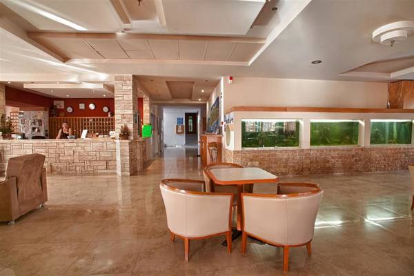 Empfangsbereich des Ilios K. Village Resorts mit Sitzbereich und Rezeption.