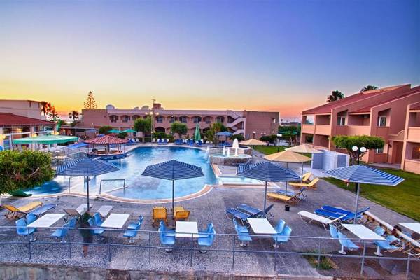 Außenbereich des Ilios K. Village Resorts mit Swimmingpool, Sonnenliegen und Sonnenschirmen