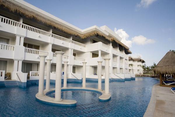 Grand Riviera Princess Hotel mit einem großen Swimmingpool und weißen Gebäuden im Hintergrund.