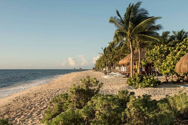 Strand des Grand Riviera Princess Hotels mit Sonnenliegen und Strohhütten