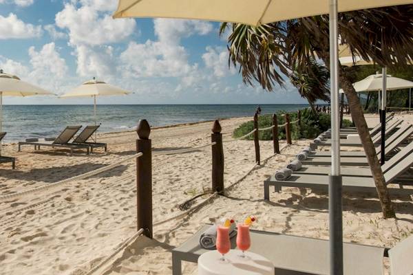Strandszene mit weißen Sonnenschirmen und Liegestühlen am Grand Riviera Princess Hotel.