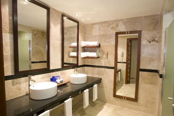 Badezimmer im Grand Riviera Princess Hotel mit zwei Waschbecken, Spiegeln und Handtüchern.