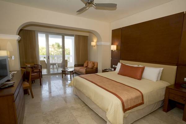 Luxuriöses Zimmer im Grand Riviera Princess Hotel mit Doppelbett, Balkonzugang und modernem Dekor.