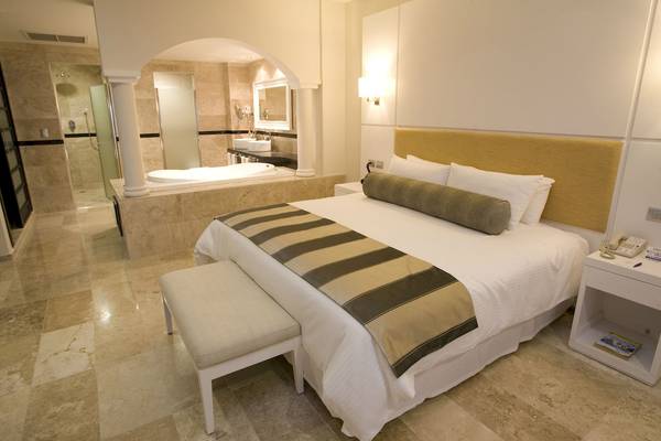 Schlafzimmer im Grand Riviera Princess Hotel mit Doppelbett und Badewanne