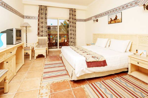 Hotelzimmer im Sentido Mamlouk Palace mit Doppelbett, Fernseher, Schreibtisch und Balkonzugang.