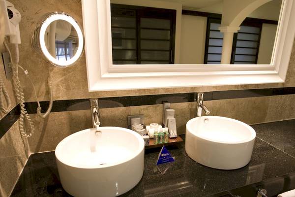 Badezimmer im Grand Riviera Princess Hotel mit zwei Waschbecken, Spiegel und Handtuecher.