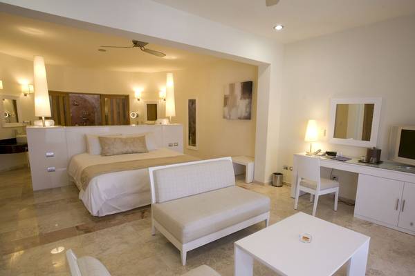 Schlafzimmer im Grand Riviera Princess Hotel mit einem Bett, einem Schreibtisch und einer Couch.