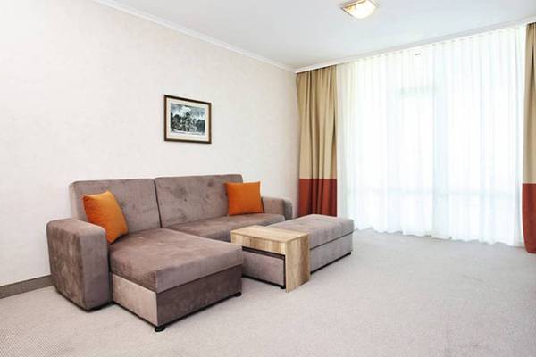Wohnzimmer im Festa Panorama Hotel mit Sofa, Couchtisch und Fernseher.