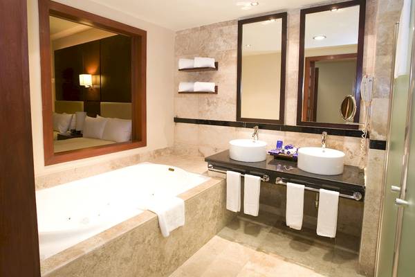 Badezimmer im Grand Riviera Princess Hotel mit Badewanne und Spiegeln