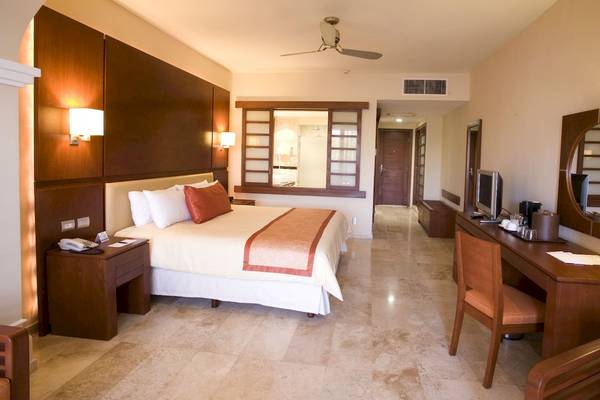 Hotelzimmer der Grand Riviera Princess mit Bett, Schreibtisch, Fernseher und Möbeln.