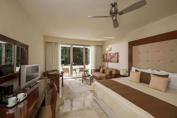 Innenansicht der Suite im Grand Riviera Princess Hotel mit Bett, Fernseher, Schreibtisch und Balkon