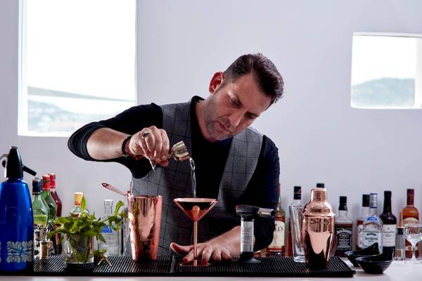 Ein Barkeeper in der Bar des Absolute Mykonos Suites & More Hotels, der einen Cocktail mixt.