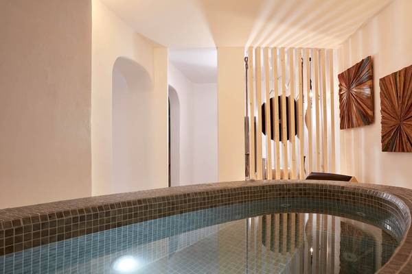 Innenpool im Absolute Mykonos Suites & More Hotel mit gefliesten Wänden und Boden.
