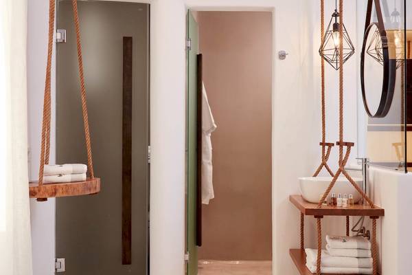 Badezimmer im Absolute Mykonos Suites & More Hotel mit Hängeschaukel, Duschtür und Regalen.