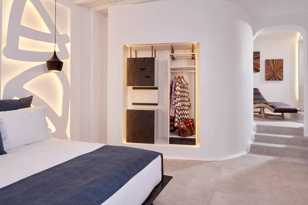 Schlafzimmer des Absolute Mykonos Suites & More Hotels mit weißem Bett und geräumigem Kleiderschrank.
