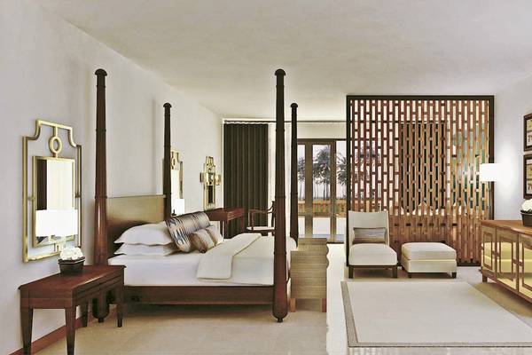 Ein elegantes Hotelzimmer im Blue Water Hotel und Spa mit einem großen Bett, weißen Wänden und Holzmöbeln.