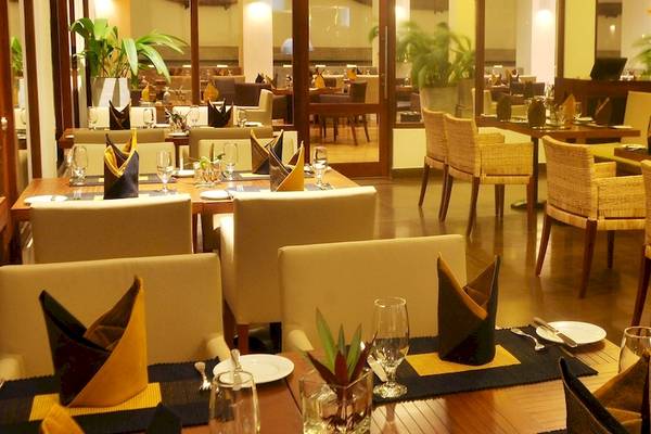 Restaurant-Innenbereich des Blue Water Hotel and Spa mit gedeckten Tischen und Stühlen.