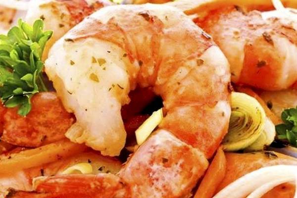 Gegrillte Garnelen mit Zwiebeln und Petersilie auf einem Teller serviert