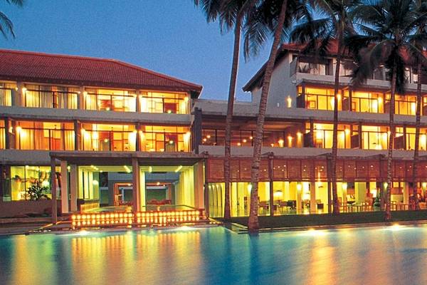 Die Abendansicht des Blue Water Hotel and Spa mit beleuchtetem Gebäude und Swimmingpool.