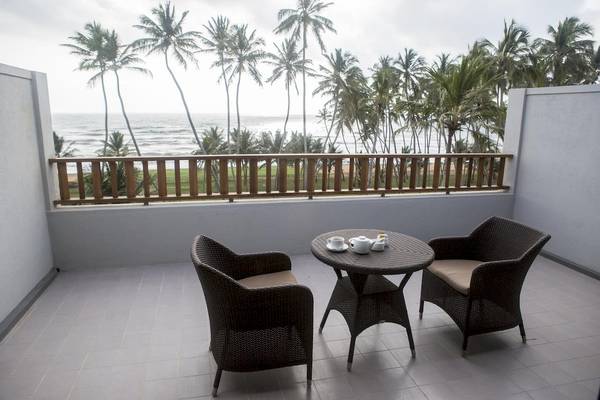 Ein Balkon mit Möbeln und Blick auf den Strand im Blue Water Hotel und Spa.