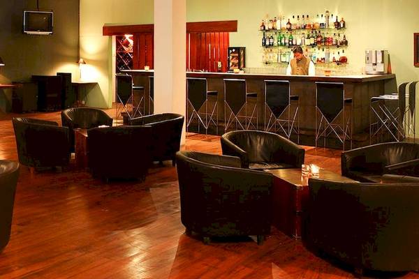 Barbereich des Blue Water Hotel and Spa mit Hockern, Bar und Inventar.