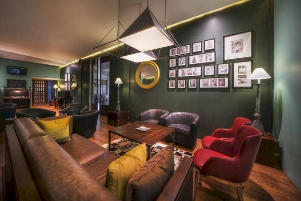 Innenbereich des Blue Water Hotel und Spa mit grünen Wänden, Sofas, Sesseln und Fotos an der Wand.