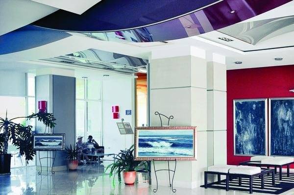 Empfangsbereich des Festa Panorama Hotels mit roter Wand, Kunstwerken und Sitzgelegenheiten.