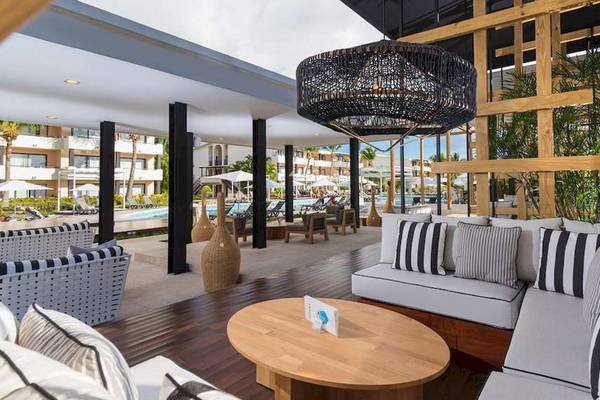 Hotellounge mit Blick auf den Pool und modernen Möbeln, hängende Laterne.