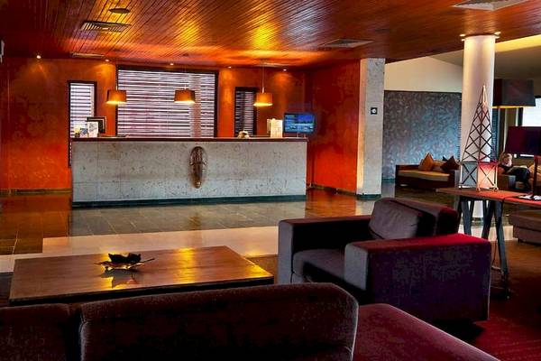 Empfangsbereich des Catalonia Royal Bavaro Hotels mit Rezeptionstresen, Sitzbereich und Fernseher.
