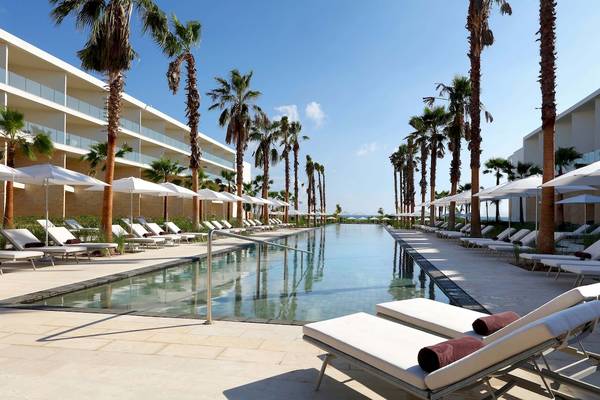Außenpool des Grand Palladium Costa Mujeres Resort & Spa mit weißen Liegen und Palmen