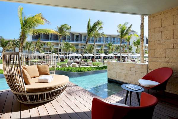 Terrasse des Grand Palladium Costa Mujeres Resorts mit Swimmingpool und Sonnenliegen.