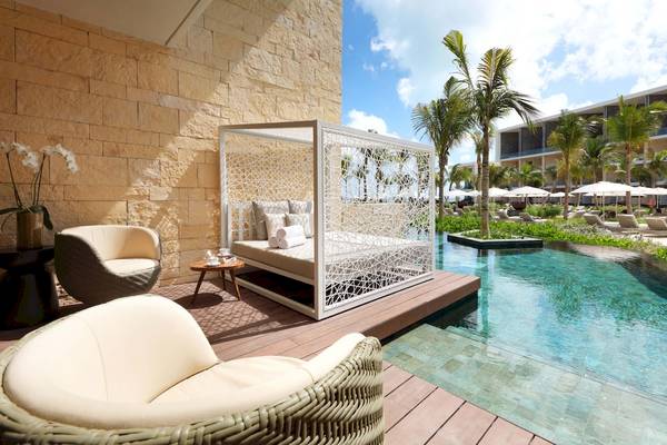 Außenpool-Loungebereich im Grand Palladium Costa Mujeres Resort & Spa mit weißem Baldachin und Möbeln.