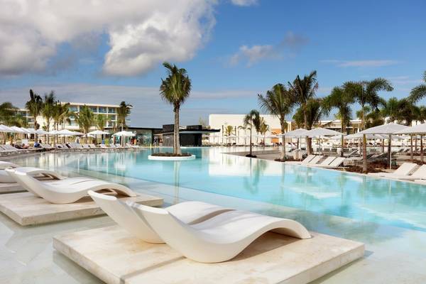 Grand Palladium Costa Mujeres Resort & Spa Pool mit weißen Sonnenliegen und Palmen