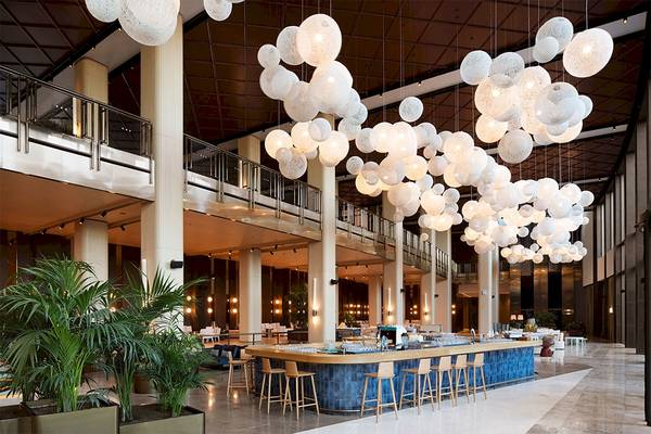 Lobby des Voyage Belek Golf & Spa Hotels mit Bar und runden Lampen.