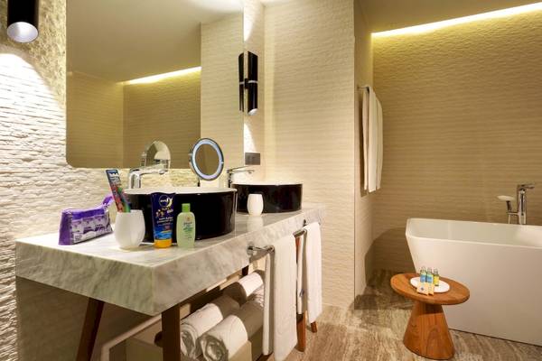 Badezimmer im Grand Palladium Costa Mujeres Resort & Spa mit Marmorarbeitsplatte, zwei Waschbecken und Badewanne.