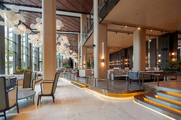 Lobby des Voyage Belek Golf & Spa Hotels mit Möbeln, Leuchten und Pflanzen.