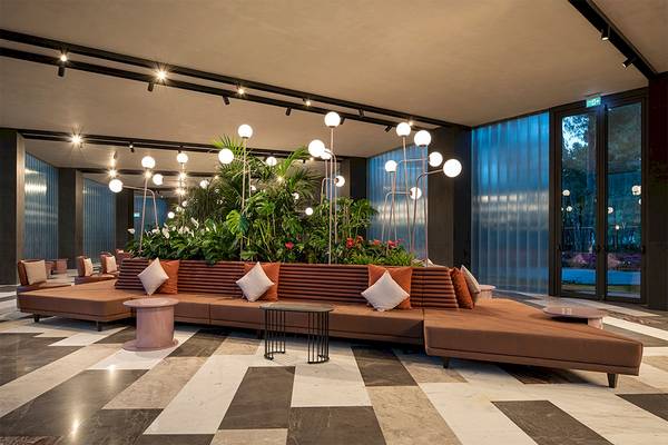 Lobbybereich des Voyage Belek Golf & Spa Hotels mit Loungesofas, Pflanzen und Beleuchtung.