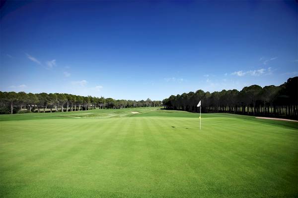 Golfplatz im Voyage Belek Golf & Spa Hotel mit einer weißen Fahne im Vordergrund.